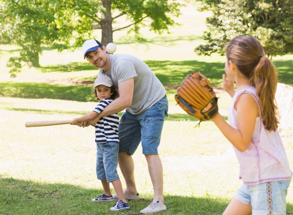 Family of three playing baseball in the park Family of three playing baseball in the park
