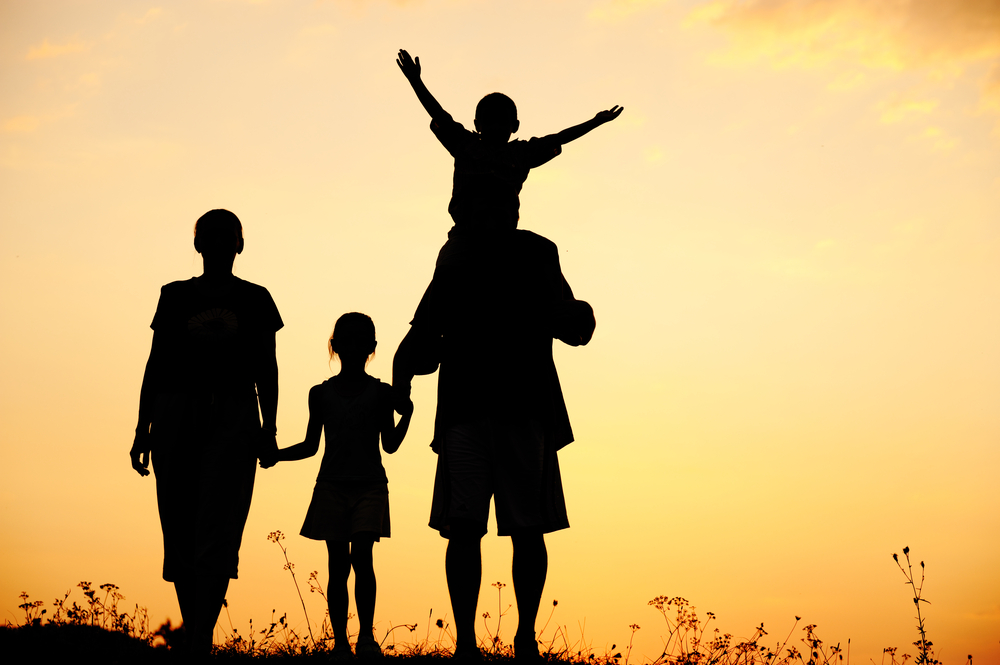 Silhouette, happy children with mother and father, family at sunset, summertime